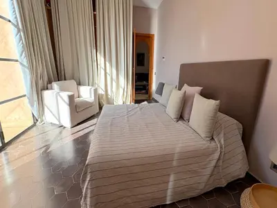 a bedroom with a large bed and two chairs at Palais Meryem in Marrakech