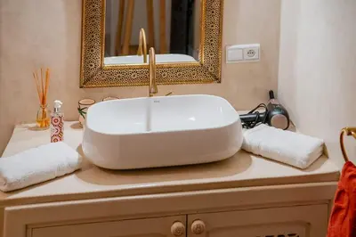 a bathroom with a white sink and a mirror at Riad Sohayna with Rooftop Pool 3BR Oasis in Marrakech