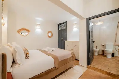 a bedroom with a bed and a bathroom with a toilet at Riad Sohayna with Rooftop Pool 3BR Oasis in Marrakech