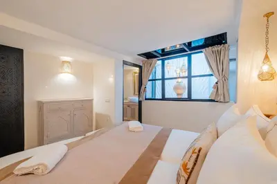 a bedroom with a large bed with a window at Riad Sohayna with Rooftop Pool 3BR Oasis in Marrakech