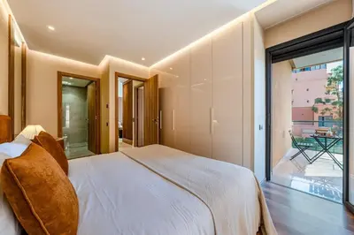 a bedroom with a large bed and a large window at Magnifique appt Hivernage Gueliz in Marrakech