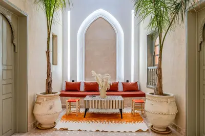 a living room with a red couch and two palm trees at Riad Exotika a Oasis with Pool, 7 min to Jemaa El Fna in Marrakech