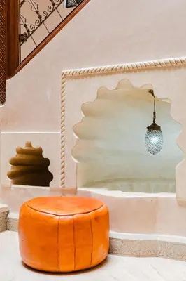 an orange ottoman sitting on the floor in a room at Riad Marrakech Oasis complexe in Marrakech