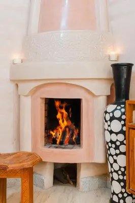 a brick fireplace with a fire in it at Riad Marrakech Oasis complexe in Marrakech