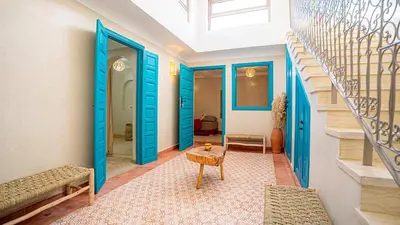 a hallway with blue doors and a table at riad Orazur in Marrakech