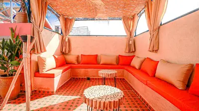 a red couch in a room with windows at riad Orazur in Marrakech