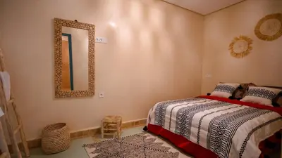 a bedroom with a bed and a mirror on the wall at riad Orazur in Marrakech