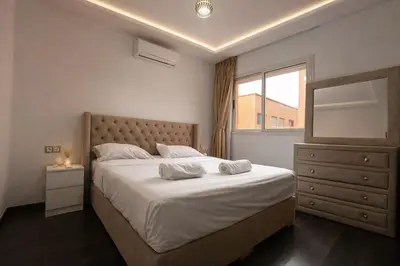 a bedroom with a large bed and a window at Studio Chic & Haut Standing - Parking Gratuit in Marrakech