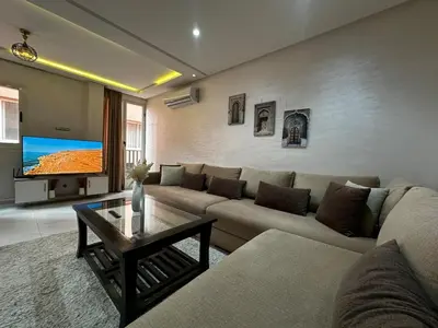 a living room with a couch and a tv at Studio Chic & Haut Standing - Parking Gratuit in Marrakech