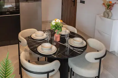 a dining table and chairs with a black table and flowers at Élégance et Confort au Centre de Marrakech - Hivernage in Marrakech