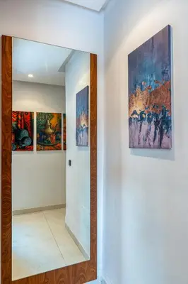 a hallway with three paintings on the wall and a mirror at Élégance et Confort au Centre de Marrakech - Hivernage in Marrakech