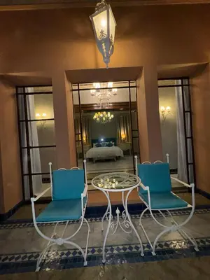 a living room with a table and two chairs at Golf mountain camels sereine holiday treat in Marrakech