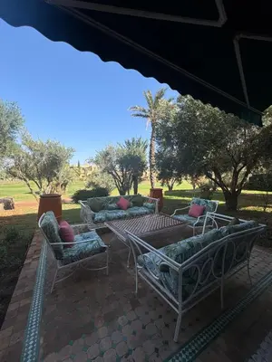 a patio with couches and a table and chairs at Golf mountain camels sereine holiday treat in Marrakech