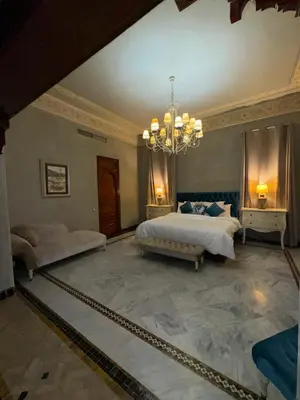 a large bedroom with two beds and a chandelier at Golf mountain camels sereine holiday treat in Marrakech