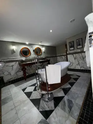 a bathroom with a tub and a sink and mirror at Golf mountain camels sereine holiday treat in Marrakech