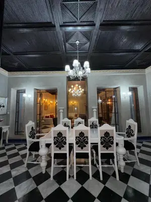 a dining room with a white table and chairs at Golf mountain camels sereine holiday treat in Marrakech