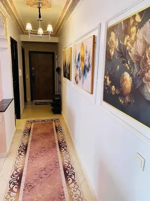 a hallway with paintings on the walls and a rug at Moroccan-style apartment rental in Marrakech in Marrakech