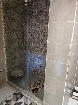 a shower with a glass door in a bathroom at arrive as a guest , turn to a local in Marrakech
