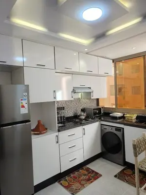 a kitchen with white cabinets and a stainless steel refrigerator at arrive as a guest , turn to a local in Marrakech