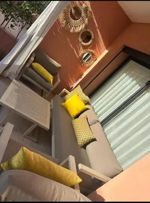 a room with a window with pillows and a couch at Luxury Noria Apartment - Pool - Security - airport in Oulad Akkou