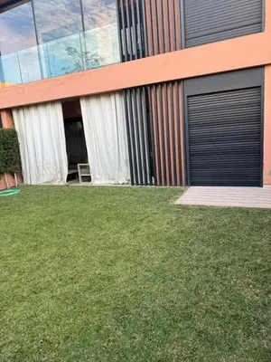 a house with a lawn in front of a building at Luxury Noria Apartment - Pool - Security - airport in Oulad Akkou
