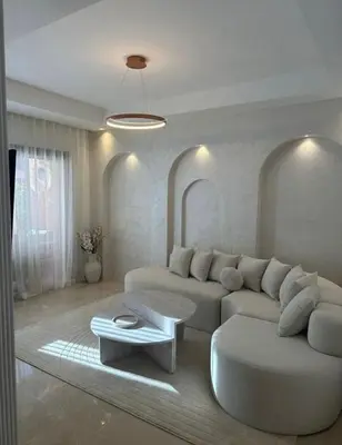 a living room with a white couch and a table at Luxury Noria Apartment - Pool - Security - airport in Oulad Akkou