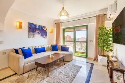 a living room with a couch and a table at Chic Majorelle Apartment with Balcony and city view Central & Calm Marrakech in Marrakech