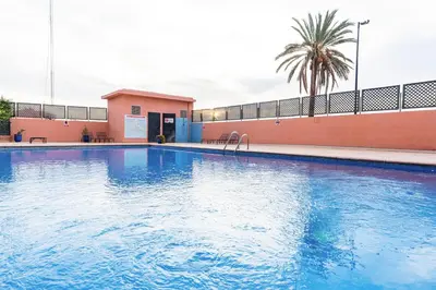 a large blue swimming pool next to a building at Chic Majorelle Apartment with Balcony and city view Central & Calm Marrakech in Marrakech