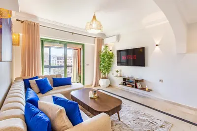 a living room with a couch and a tv at Chic Majorelle Apartment with Balcony and city view Central & Calm Marrakech in Marrakech