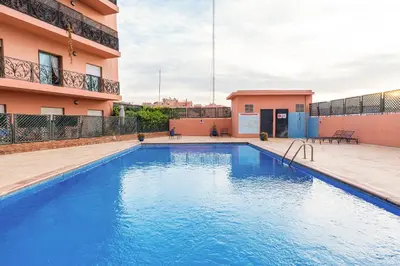 a swimming pool in front of a building at Chic Majorelle Apartment with Balcony and city view Central & Calm Marrakech in Marrakech