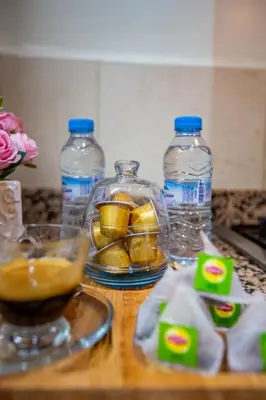 a counter with bottles of water and fruit in a bowl at Chic Majorelle Apartment with Balcony and city view Central & Calm Marrakech in Marrakech