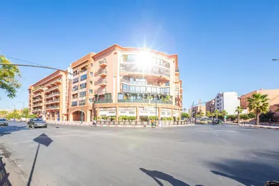 a building on a street with the sun shining on it at Chic Majorelle Apartment with Balcony and city view Central & Calm Marrakech in Marrakech