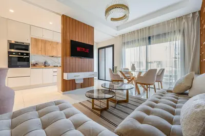 a living room with a couch and a table at Amal Cozy - Modern Design, 4 Pools & HD Wifi in Marrakech