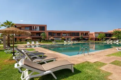a swimming pool with lounge chairs and a hotel at Amal Cozy - Modern Design, 4 Pools & HD Wifi in Marrakech