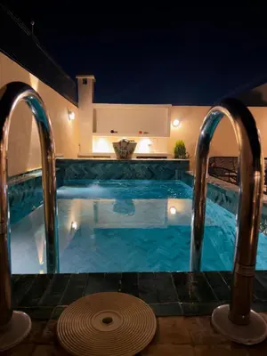 a swimming pool at night with two faucets at Riad Marhaba in Marrakech
