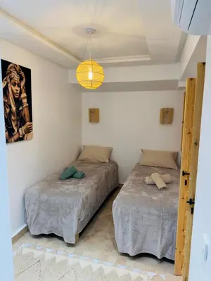 two beds in a room with a picture on the wall at Riad Marhaba in Marrakech