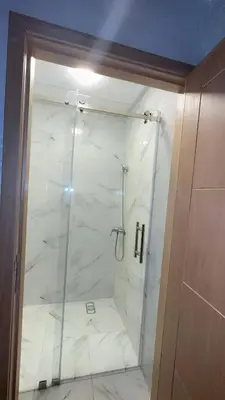a bathroom with a shower with a glass door at Chic appartement Marrakech in Marrakech