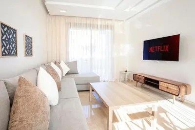 a living room with a couch and a table at The Calm Haven - Marrakech - Prestigia in Marrakech