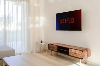 a living room with a television on a wall at The Calm Haven - Marrakech - Prestigia in Marrakech