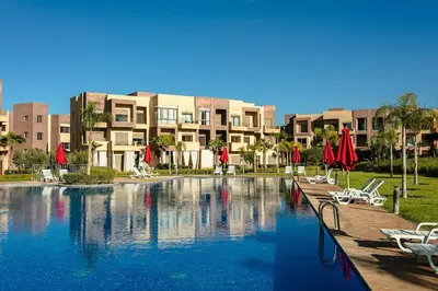 a large swimming pool in front of a building at The Calm Haven - Marrakech - Prestigia in Marrakech