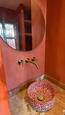 a bathroom with a circular sink and a mirror at Riad TILÉLI in Marrakech