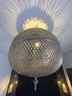 a large metal light on top of a table at Riad TILÉLI in Marrakech