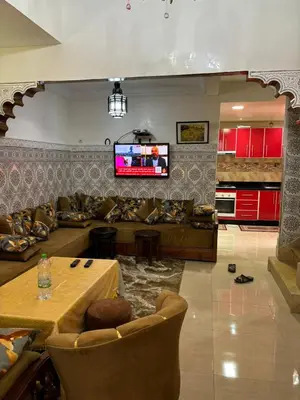 a living room with a couch and a table and a tv at Ryad Karima in Marrakech