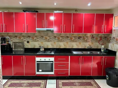a red kitchen with red cabinets and a microwave at Ryad Karima in Marrakech