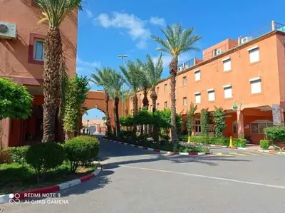 a street with palm trees in front of a building at Ryad Karima in Marrakech