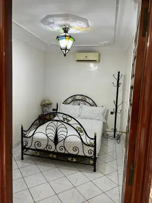a bedroom with a bed and a chandelier at Ryad Karima in Marrakech