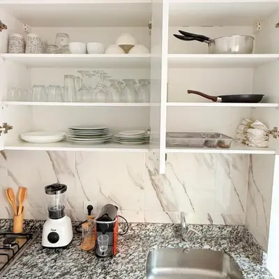 a kitchen counter with a sink and shelves with dishes at Meriso Downtown Free Parking in Marrakech