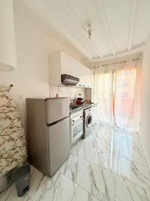 a kitchen with a refrigerator and a stove top oven at Meriso Downtown Free Parking in Marrakech