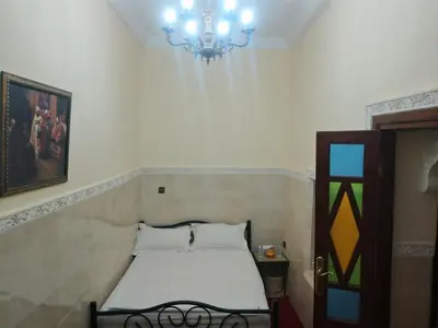 a bedroom with a bed and a chandelier at House of Diamonds in Marrakech