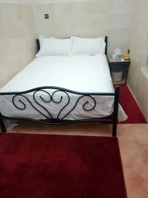 a bed with white sheets and a black frame at House of Diamonds in Marrakech